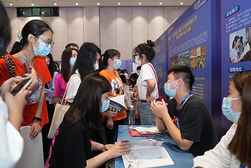 Graduates talk to employers at a job fair in Dongguan, Guangdong province, June 11, 2022. VCG