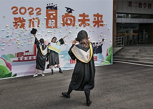 Graduates pose for photos at a university in Chengdu, Sichuan province, June 8, 2022. Liu Guoxing/VCG