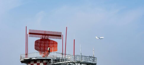airport radar tower with airplane in sky